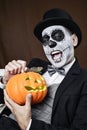 Man with mexican calaveras makeup and carved pumpkin Royalty Free Stock Photo