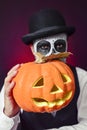 Man with mexican calaveras makeup and carved pumpkin Royalty Free Stock Photo
