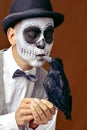 Man with mexican calaveras makeup kissing a black crow Royalty Free Stock Photo