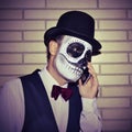 Man with mexican calaveras makeup, on the phone Royalty Free Stock Photo