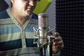 A man at a microphone in a recording Studio. Musical creativity