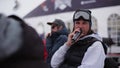 Man with microphone say among snowboarders and skiers on ski resort. Sport