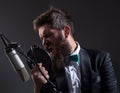 Man with microphone singing song. Musician in music hall. Music festival. Funny guy singing in karaoke. Royalty Free Stock Photo