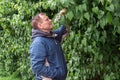 Man, middle-aged, handsome smiling, stands against the background of green nature Royalty Free Stock Photo