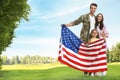 Man in military uniform with American flag and his family at park Royalty Free Stock Photo