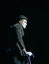 Man mime dressed like sad clown performing on a black background