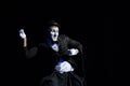 Man mime dressed like sad clown performing on a black background