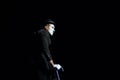 Man mime dressed like sad clown performing on a black background