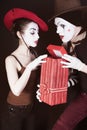 A man mime gives a gift to a woman