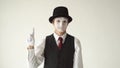 Man mime standing on white background and looking to the camera. Finger waves side to side to express `no` or `tsk tsk.`