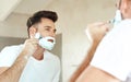 Man, mirror and shaving cream on face in bathroom for grooming, skincare or morning routine. Reflection, beard foam and Royalty Free Stock Photo