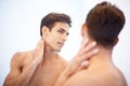 Man, mirror and thinking on skincare and beauty in bathroom, cosmetics and dermatology or facial treatment. Male person