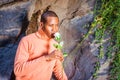 Young African American Man holding white flower, waiting for you Royalty Free Stock Photo