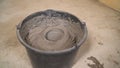 Man is mixing grey concrete and prime in the bucket. Mixed grey concrete and prime in the bucket - Renovating. The putty solution