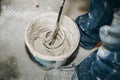 Man is mixing putty in the bucket Grind of wall. Maintenance repair works renovation in the flat. Restoration indoors. Concrete