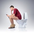 Man with mobile phone sitting on the toilet Royalty Free Stock Photo