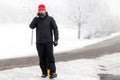 Man with mobile phone is walking across a icy street Royalty Free Stock Photo