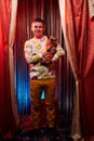 Man model with a small dog on the theater stage. Photo shoot in the circus style