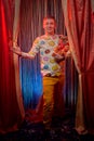 Man model with a small dog on the theater stage. Photo shoot in the circus style