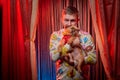 Man model with a small dog on the theater stage. Photo shoot in the circus style