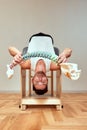 A man with a model of the spine in his hands during Pilates on the reformer. A young man shows how the spine bends when