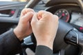 A man in a modern car. Hands hitting the steering wheel with anger