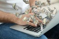 Man with modern laptop and flying dollar banknotes, closeup. People make money online Royalty Free Stock Photo