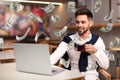 Man with modern laptop and flying dollar banknotes at table. People make money online Royalty Free Stock Photo