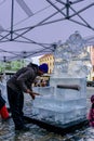 A man is modifying a statue of ice at a carnival in Olomouc