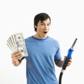 Man with money and gas nozzle. Royalty Free Stock Photo