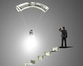 Man on money stairs looking light bulb with money parachute Royalty Free Stock Photo