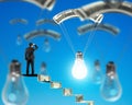 Man on money stairs looking light bulb with money parachute Royalty Free Stock Photo