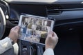 Man monitoring cctv cameras on digital tablet sitting in car Royalty Free Stock Photo