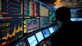 Man monitoring multiple screens displaying data graphs and codes in a dark control room Royalty Free Stock Photo