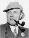 Man with a monocle, pipe and a deerstalker hat Royalty Free Stock Photo