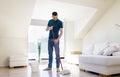 Man with mop and bucket cleaning floor at home