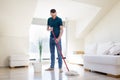 Man with mop and bucket cleaning floor at home