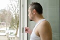 Man in the morning drinking coffee and looking out the window Royalty Free Stock Photo