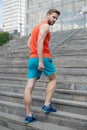 Man in motion on stairs looks back urban background. Every step brings him closer to success. Sportsman workout on