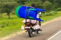 A man on a motorbike transports chairs in Uganda