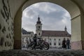 A man on a motorbike standing in front of the big square in Sibiu, Romania.