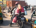 The man on the motorcycle with cans behind the back on the road on January 28, 2014 in Agra, India