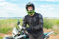 A man in motorcycle equipment sits on an enduro motorcycle