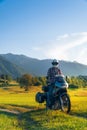 Man motorcyclist ride touring motorcycle in action. Alpine mountains on background. Biker lifestyle, world traveler. Summer sunny