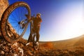 Man on mountain bike on the background of beautiful sunset. Bicycle wheel closeup.
