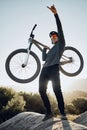 Man, mountain and bike celebrate, happy and excited after reaching summit in training. Cyclist, bicycle and rock in Royalty Free Stock Photo