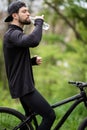 Man mountain biker drinking water in the forest Royalty Free Stock Photo