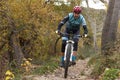 Man mountain biking in forest.