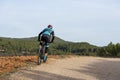 Man mountain biking in forest over a dirt track