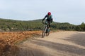 Man mountain biking in forest over a dirt track